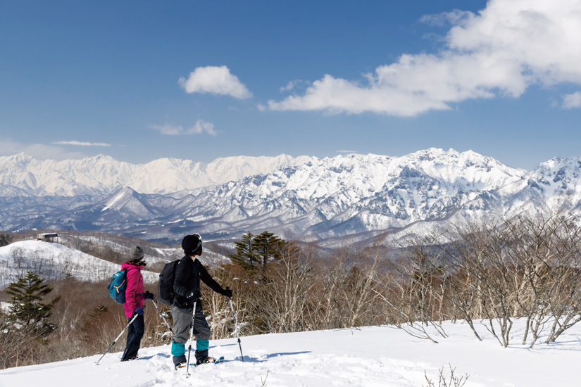 銀世界の絶景を楽しみながら歩くスノーシュー「旬ウォーク」を楽しむ二人
